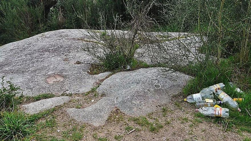 Botellas de plásticos y latas junto al petroglifo. |   // GONZALO NÚÑEZ