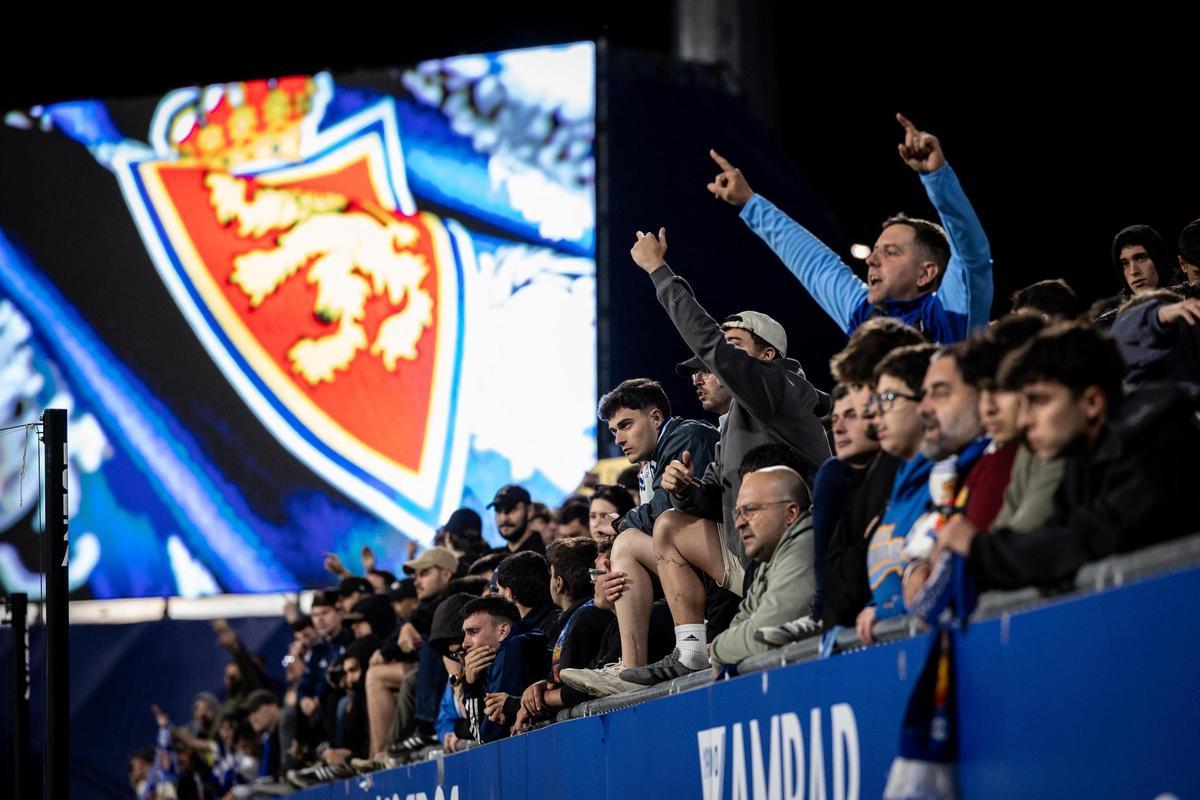 Parte de la afición protesta con el escudo del Real Zaragoza al fondo