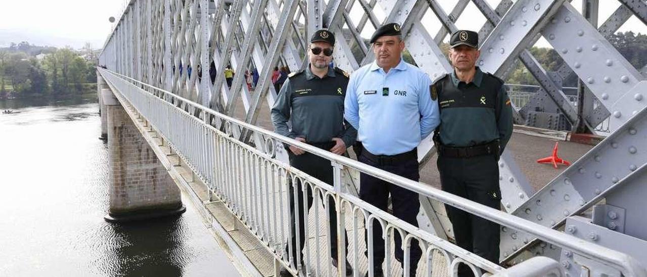 El sargento primero de la Guardia Civil Juan Antonio Martín (izq.) y el agente Manuel Bugallo (dcha.), junto al efectivo de la GNR lusa João Antonio Oliveira en el antiguo puente internacional de Tui. // R. Grobas