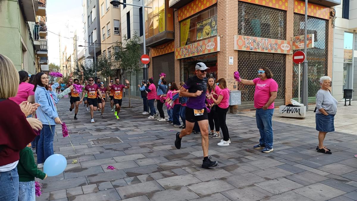 Un grupo de falleras y falleros anima en la Mitja & 10K de Gandia de 2024