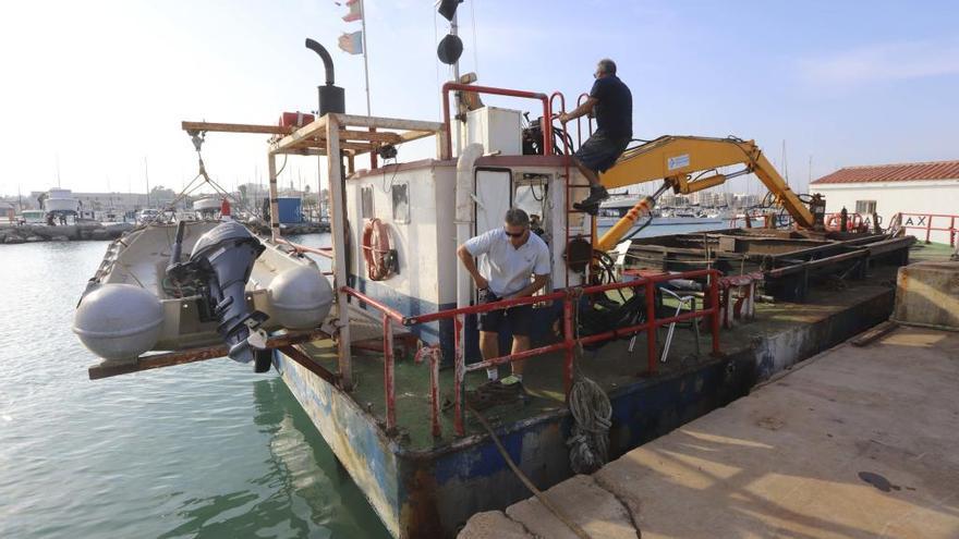 Trabajadores de la draga, haciendo ayer los preparativos para empezar a trabajar.