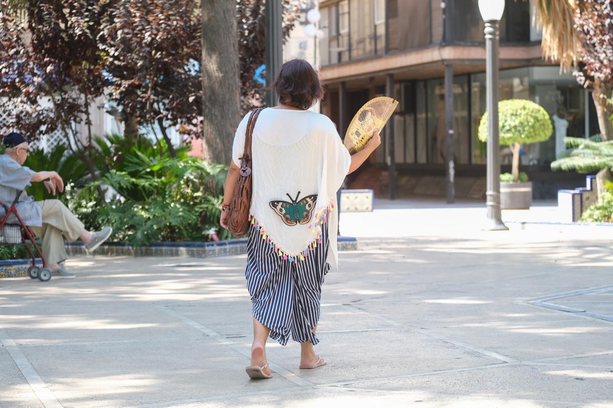 Una persona abanicándose por la calle para tratar de darse aire en una jornada tórrida del pasado verano.