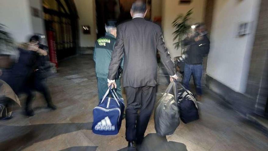 Un hombre del despacho de los abogados de Pablo Crespo llega al tribunal valenciano con tres bolsas con efectos para los cabecillas de la Gürtel. // Efe