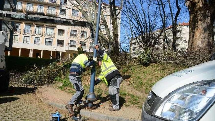 Operarios municipales retirando una farola.