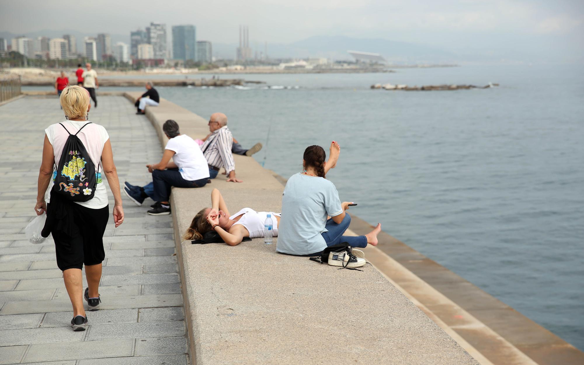 Gente descansando en la escollera del Poblenou, en Barcelona