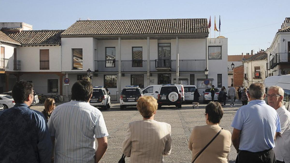 Vecinos de Valdemoro miran el despliegue policial ante el ayuntamiento.