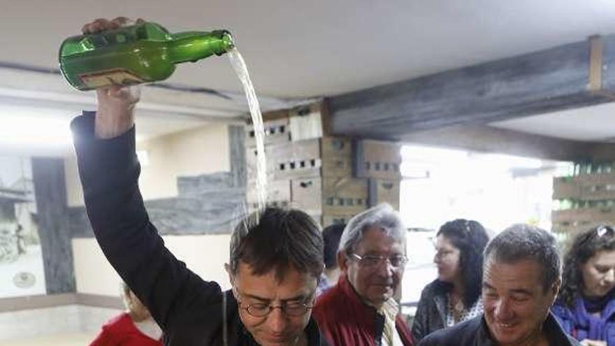 Juan Carlos Monedero escanciando ayer un culín en una sidrería de Gijón, ante Cándido González Carnero.