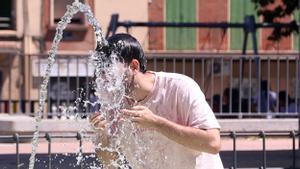 Una persona se refresca en una fuente, a 7 de agosto de 2023, en Madrid, en una nueva ola de calor