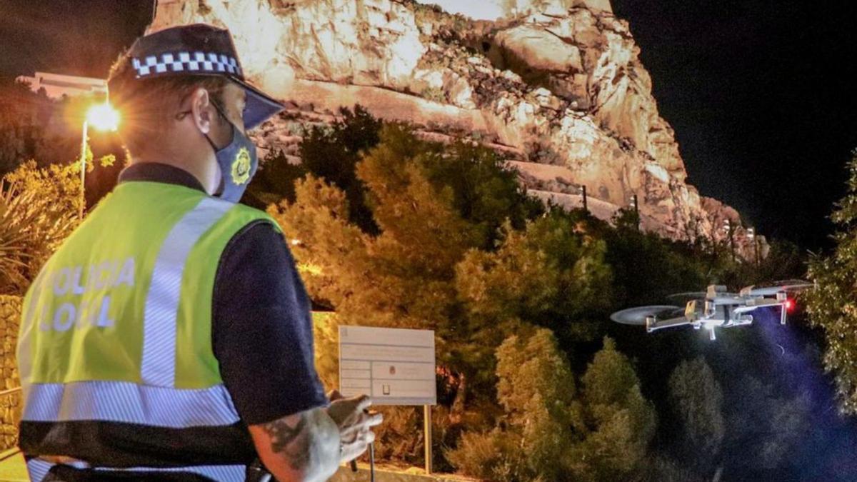Un policía local de Alicante 
opera con el dron para
 detectar botellones en 
Halloween. información