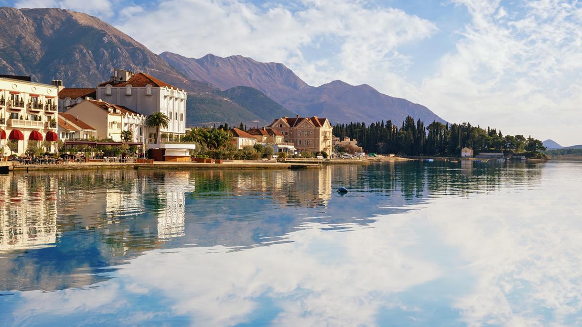 El paseo marítimo de Tivat, con las montañas que rodean la bahía de Kotor reflejadas en el Adriático.