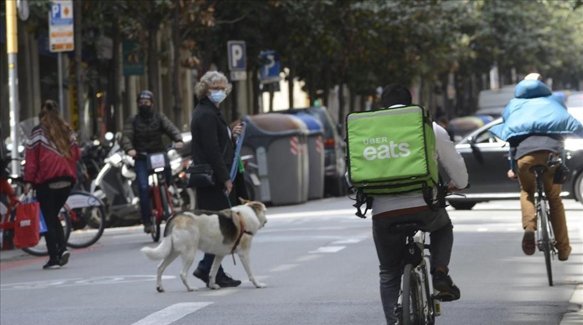 22 de ABRIL DEL 2021  BARCELONA  BUENAS PRACTICAS CON LA BICICLETA   BICI EN LA CIUDAD  CALLE DE GRAN DE GRACIA  UNA SENORA CRUZA POR EN MEDIO DE LA CALLE CON SU PERRO MIENTRAS PASAN BICIS CIRCULANDO POR EL CARRIL BUS  FOTO DE MONICA TUDELA