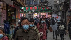 Habitantes de Wuhan pasean con mascarilla por una zona residencial de la ciudad, este viernes.