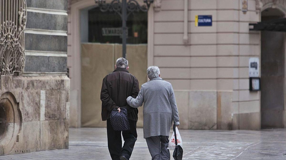 Dos personas mayores caminan juntas por la calle en València. | LEVANTE-EMV