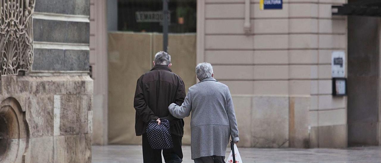 Dos personas mayores caminan juntas por la calle en València. | LEVANTE-EMV