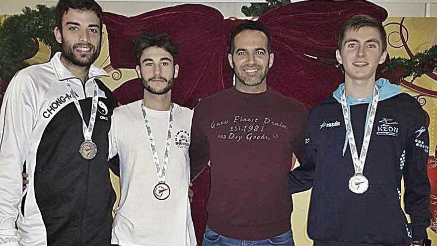 Tres de los taekwondistas posan con sus medallas tras el torneo.