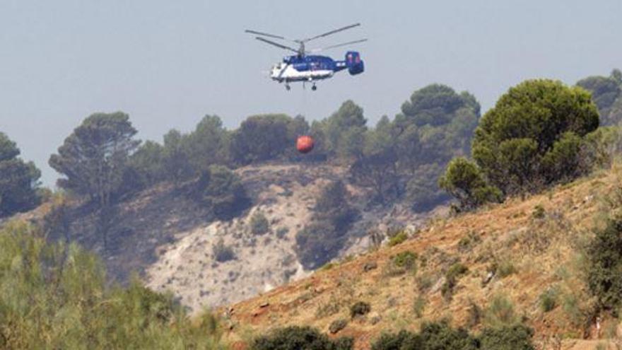 Helicóptero contra incendios actuando en los terrenos dañados.