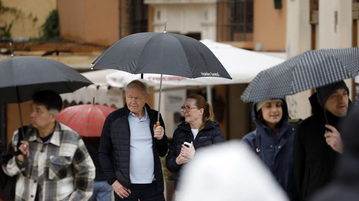 Varias personas se protegen de la lluvia en Málaga.