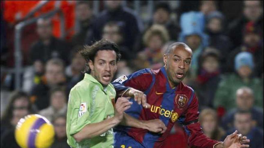 El delantero francés del Barcelona Thierry Henry dispara a puerta ante la oposición del defensa del Real Murcia Alvaro Mejía