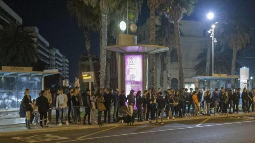 Varias personas esperan la llegada del autobús nocturno