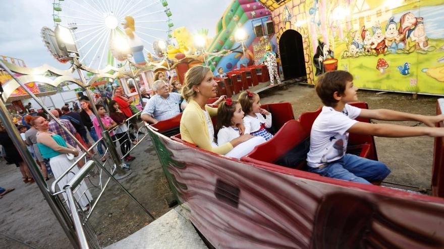 Atracciones feriales funcionando en una pasada fiesta avilesina.