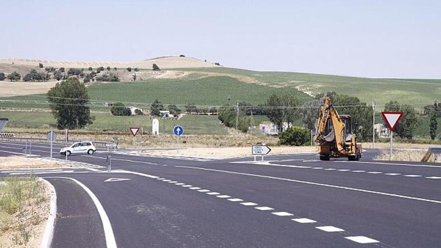 Un coche circula por una de las raquetas de la nueva carretera.