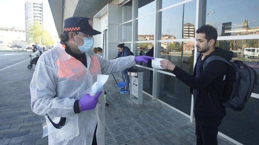 Voluntaris de protecciió civil lliurant mascaretes.