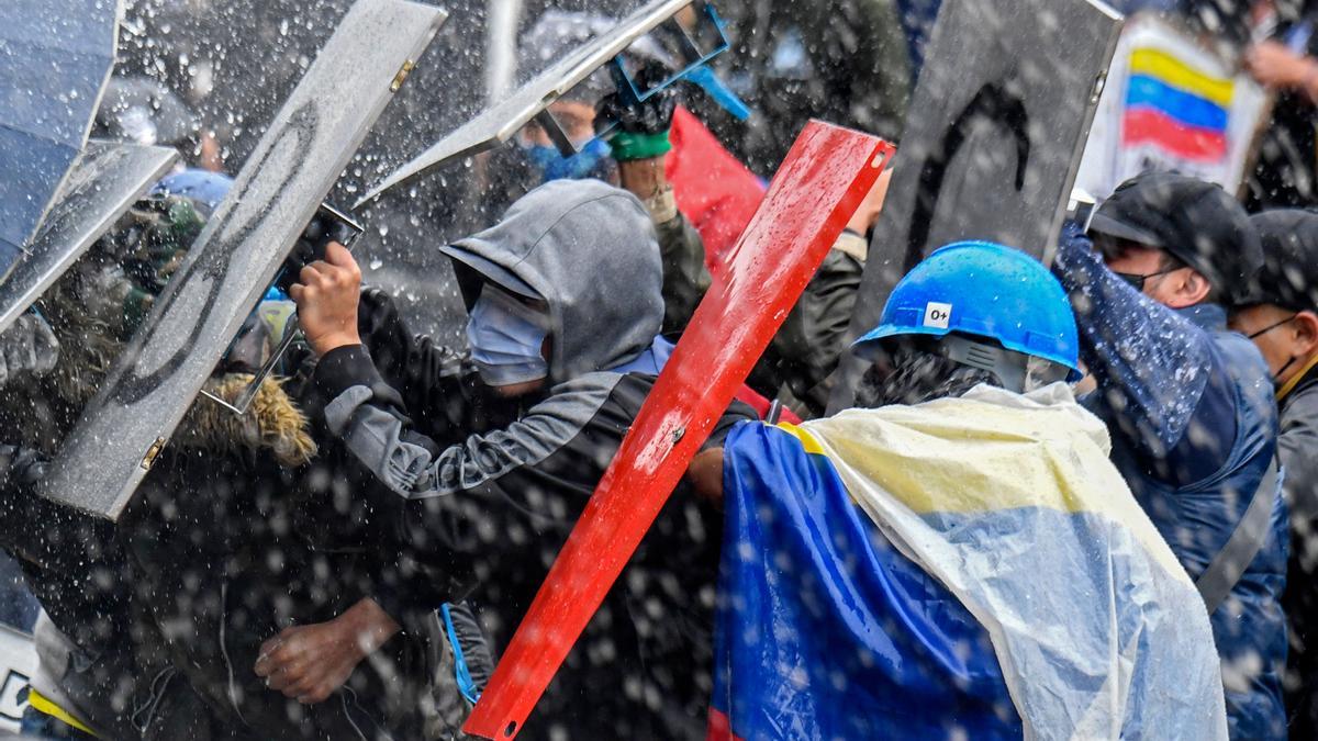 Manifestantes se enfrentan a la policía durante la protesta de este miércoles en Bogotá.