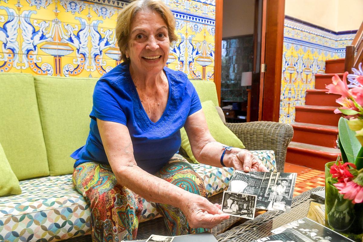 Marina López, antigua propietaria del Restaurante San Fernando, sostiene imágenes antiguas de la tienda de aceite y vinagre.