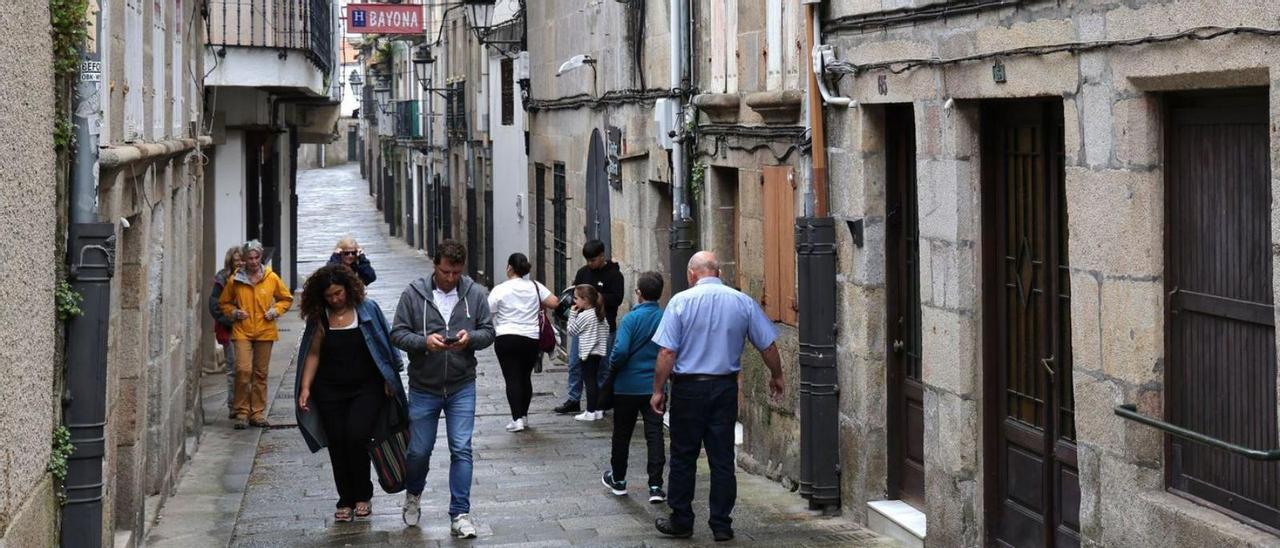 Unas personas pasean por la Rúa do Conde, ayer, en el casco viejo de Baiona.   // JOSÉ LORES