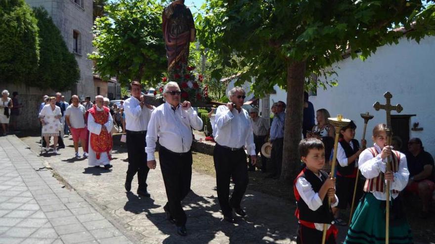 En la fotografía superior, la imagen de Santiago Apóstol, a su regreso a la iglesia; sobre estas líneas, El Zampo lleva uno de los ramos en la procesión.