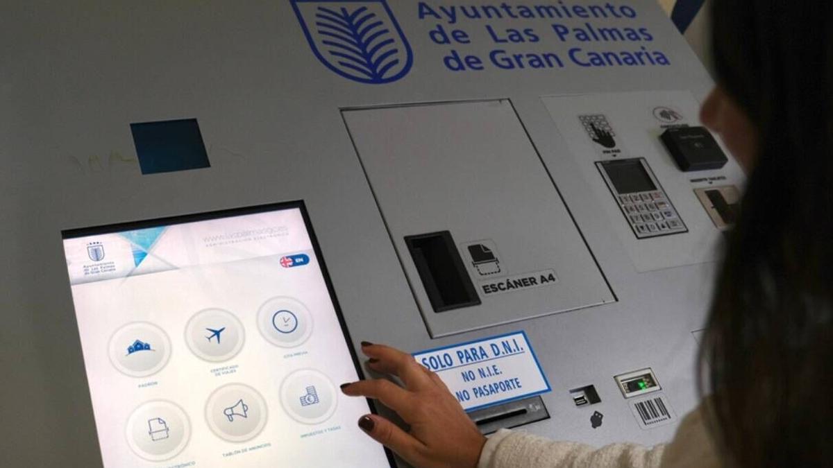 Una persona utiliza una máquina automática en el Ayuntamiento de Las Palmas de Gran Canaria.