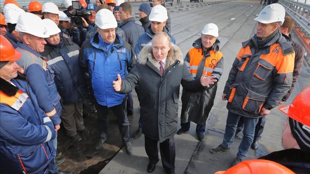 El presidente ruso, Vladimir Putin (centro) conversa con varios obreros durante la visita a las obras de construcción del puente de Crimea sobre el estrecho de Kerch, el pasado marzo.