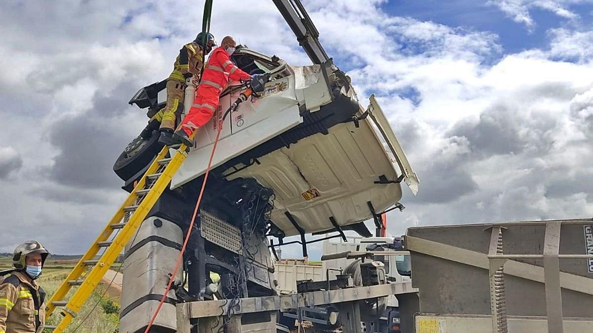 Bomberos y sanitarios acceden a la cabina del camión siniestrado para rescatar al conductor. | Bomberos Toro