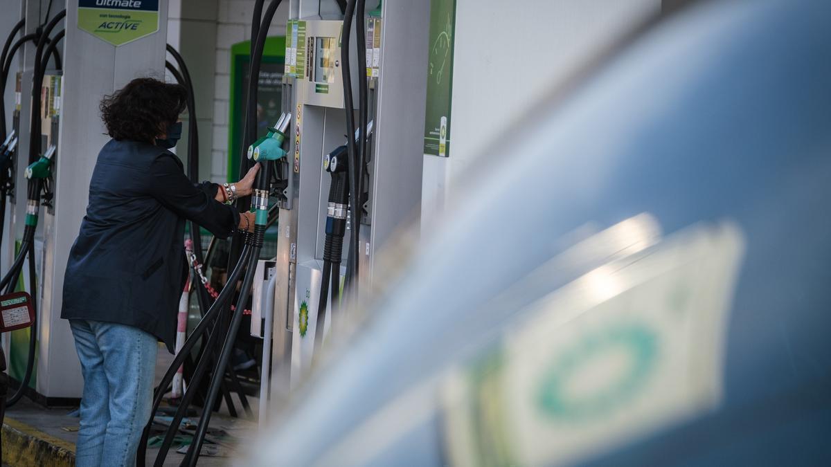 Una mujer pone gasolina en una estación de servicio.