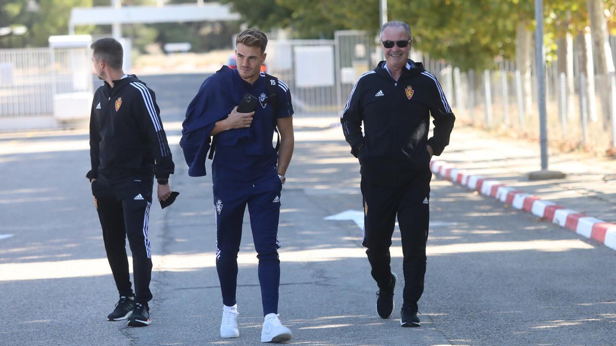 Chavarría, entre JIM y el preparador físico Javi López antes de subir al autobús para viajar a Málaga.