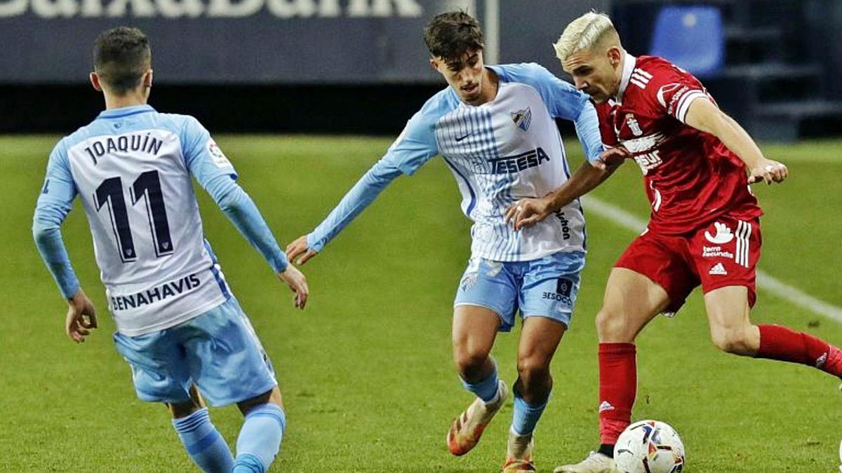 Àlex Gallar, envoltat de jugadors del Màlaga durant un partit de la temporada passada amb el Cartagena. | LALIGA