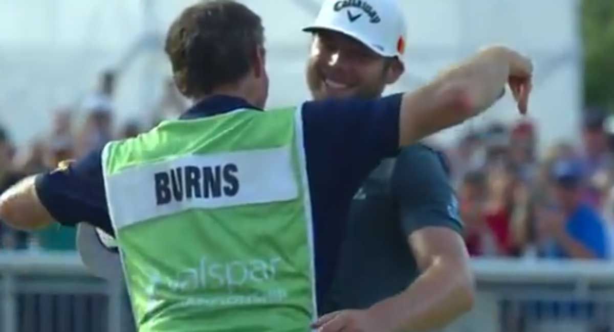 Burns se abraza a su caddie tras la victoria.