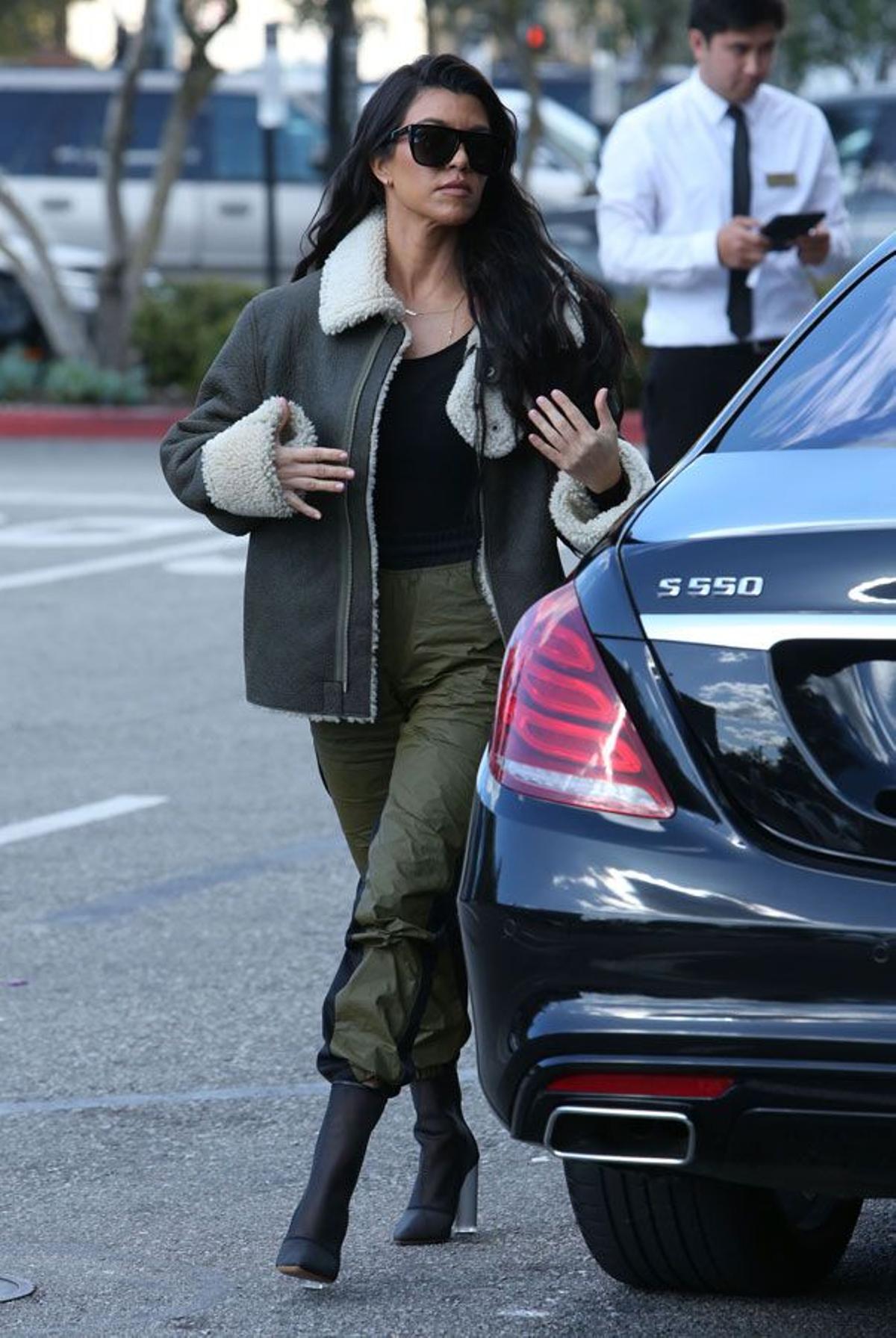Kourtney Kardashian con pantalones anchos y botines