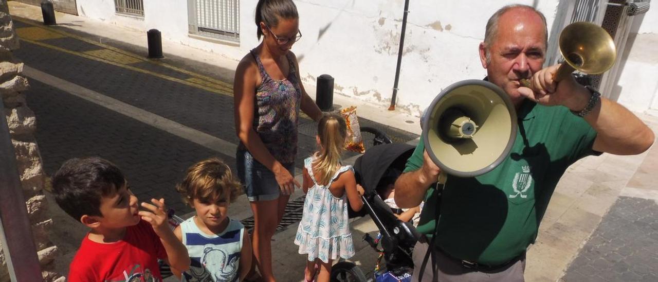 Rafa Garcia, rodeado de niños y niñas,  pronunciando uno de los bandos en una calle de Ròtova