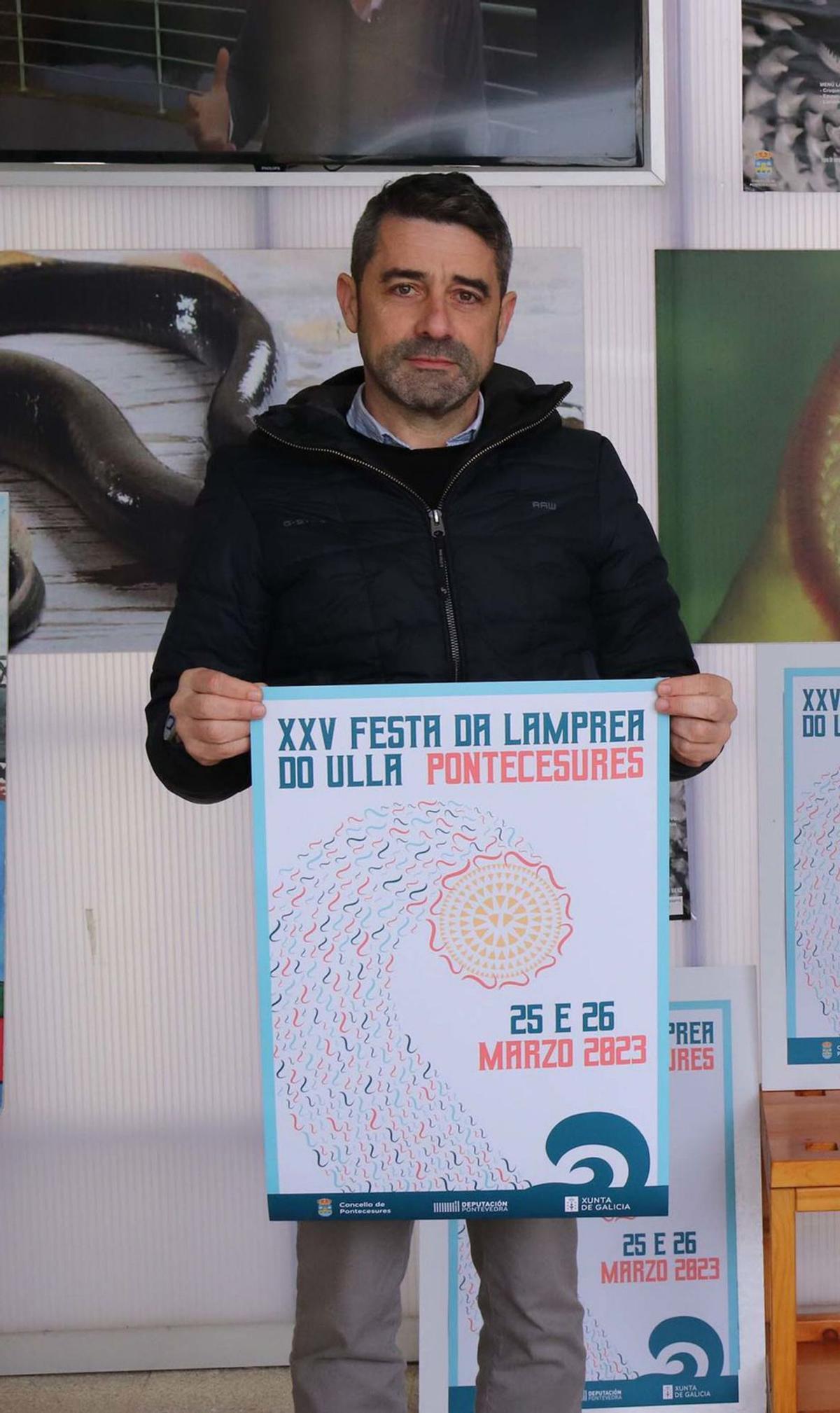 El alcalde, Juan Manuel Vidal Seage, con el cartel de la fiesta de la lamprea, a desplegar el fin de semana que viene. |   //  FDV