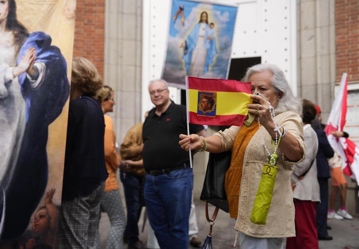 Una mujer muestra una bandera de España con la foto de Franco.
