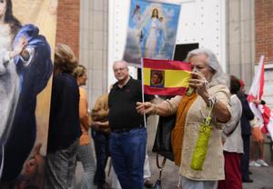 Una mujer muestra una bandera de España con la foto de Franco.