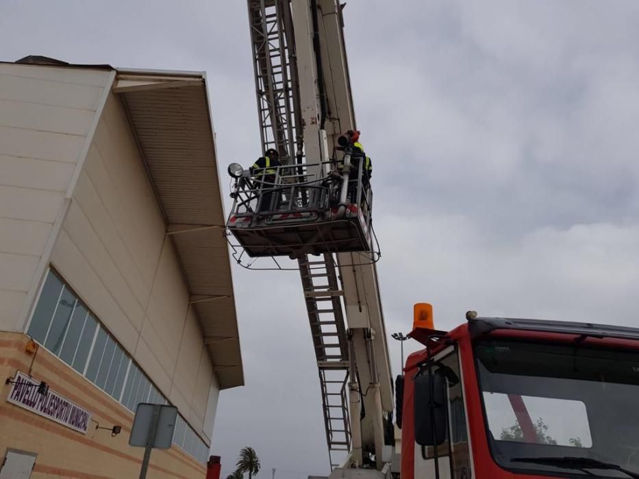 Los bomberos en el Polideportivo de Santa Pola, donde parte de la cubierta se ha caído por el fuerte viento