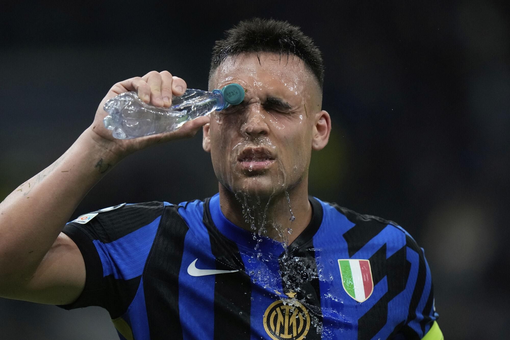Inter Milan's Lautaro Martinez splashes his face with water during the Champions League semifinal second leg soccer match between Inter Milan and Barcelona at San Siro stadium in Milan , Italy, Tuesday, May 6, 2025. (AP Photo/Luca Bruno)