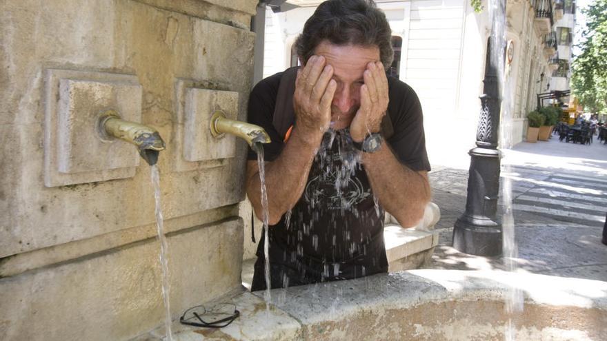 Un hombre se refresca en la fuente del Lleó de Xàtiva.