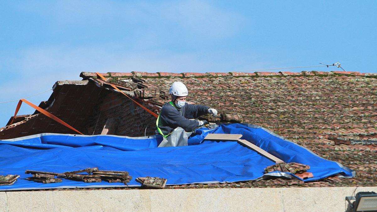 Un operario trabajando en la zona del tejado en la que se produjo el derrumbe. // Iñaki Osorio