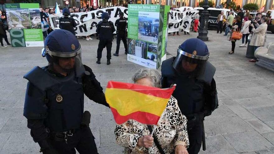 Dos agentes acompañan a una manifestante a su grupo, tras haberse acercado al de los antifascistas.