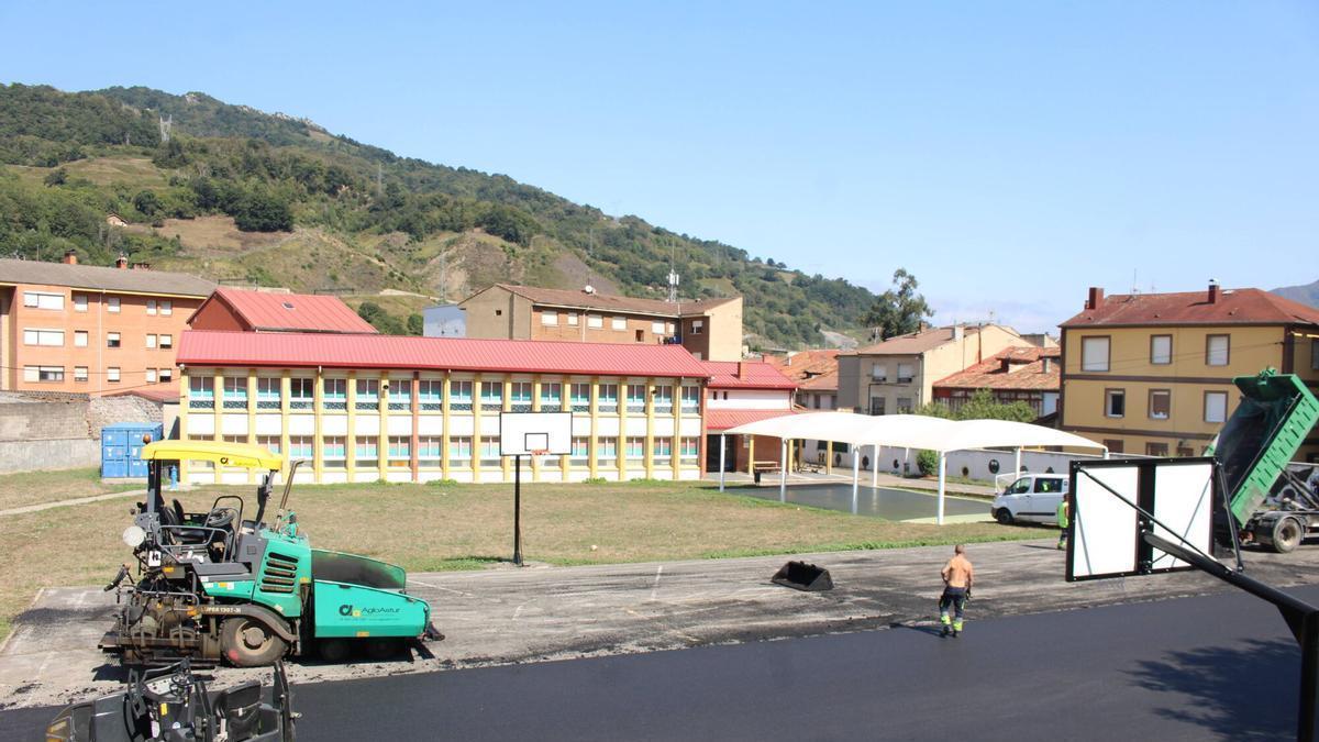 Operarios trabajando en el arreglo del patio del Colegio Rural Agrupado (CRA) de Campomanes, en Lena.
