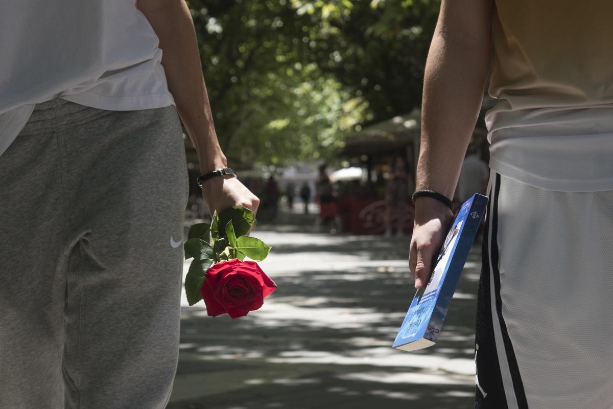 Dues persones amb una rosa i un llibre a la mà