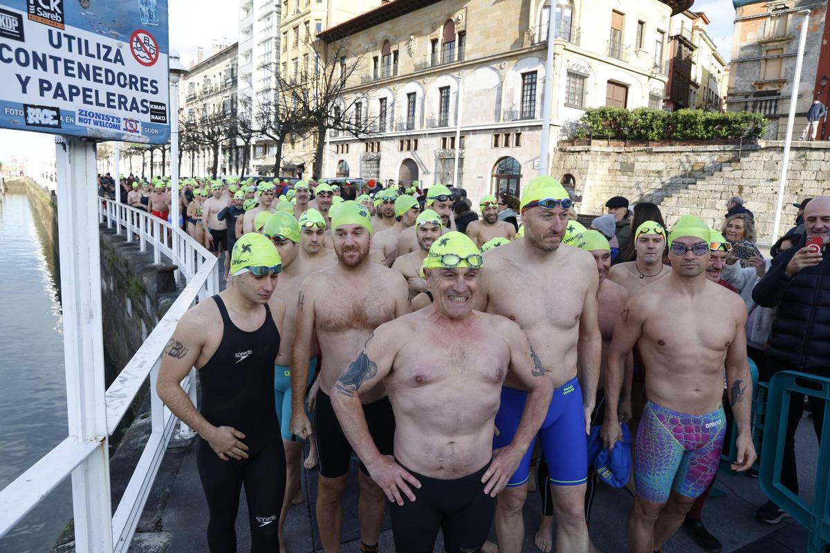 La travesía a nado de Navidad en Gijón congrega un año más a decenas de participantes (en imágenes)